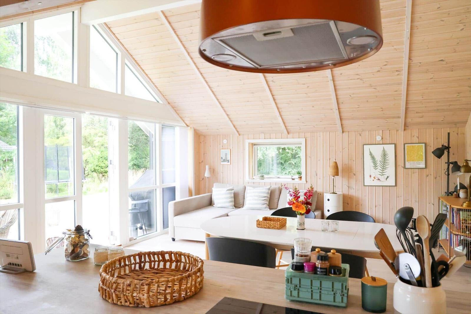 Holzwand mit Spiegel, Bildern und Schminktisch mit Blumen.