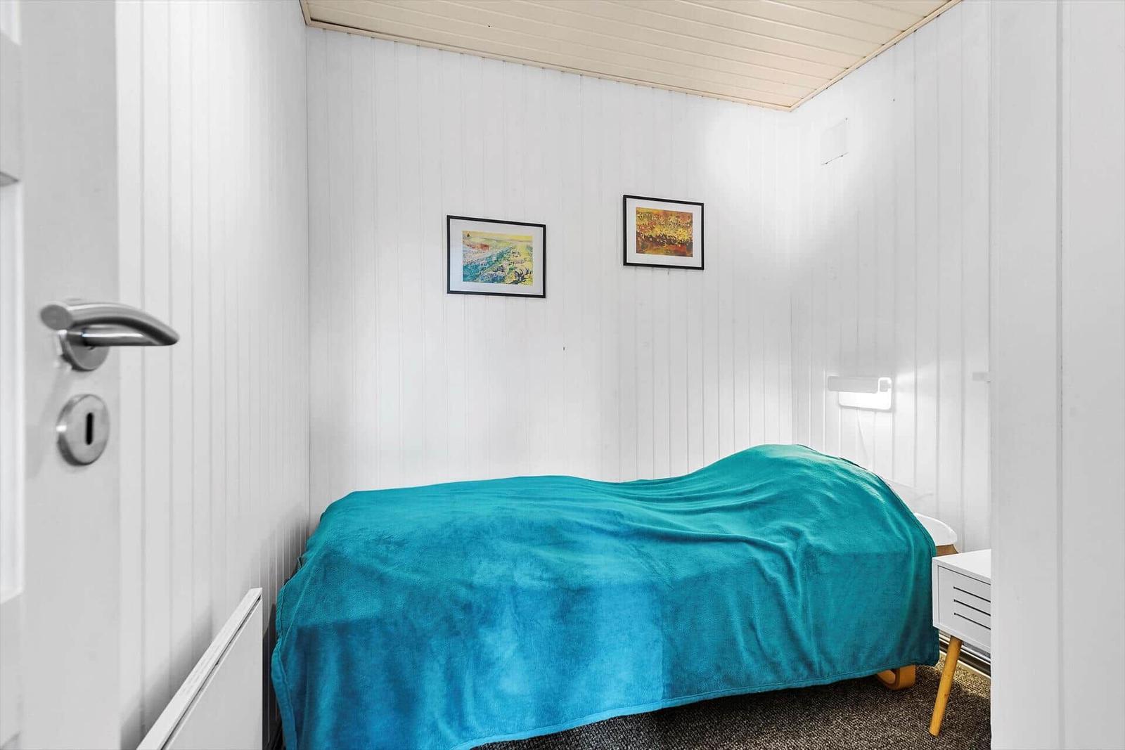 Outdoor area with table and two chairs in front of a wooden cabin in the woods.