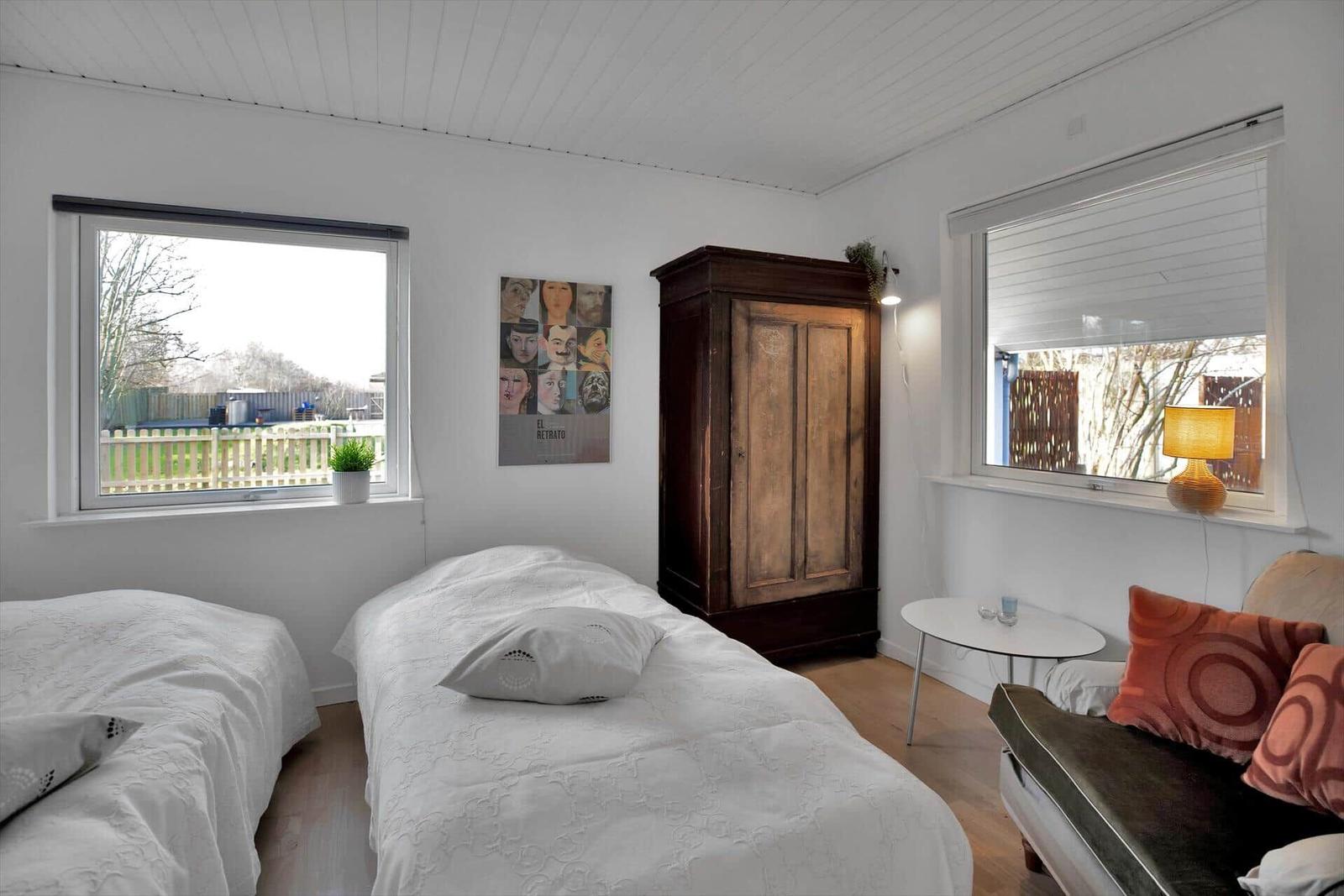 Küche mit weißen Schränken, Edelstahlherd und Dachfenster. Fenster mit Jalousie und Kücheninsel.