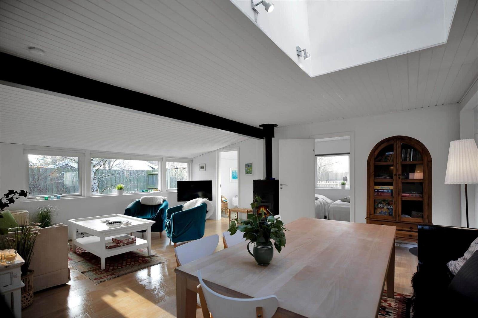Schlafzimmer mit Bett, Fenster und Wandbildern.