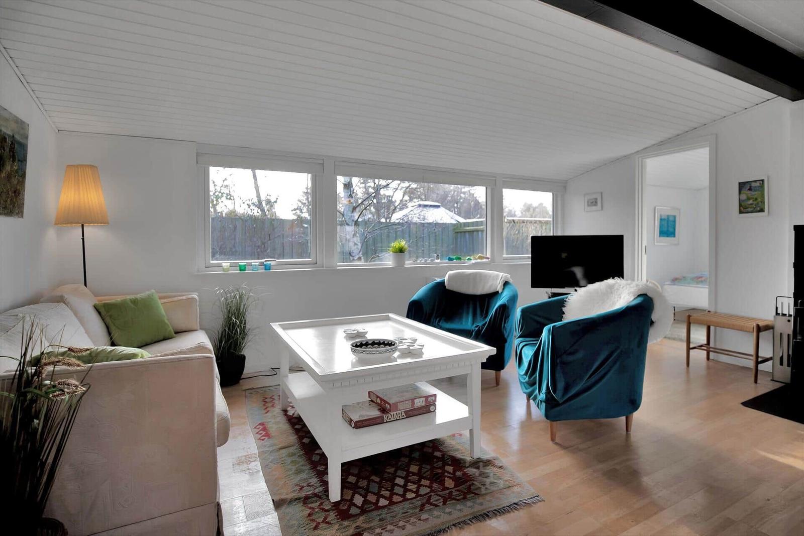 Schlafzimmer mit Bett, Schrank, Stuhl und Fenster.