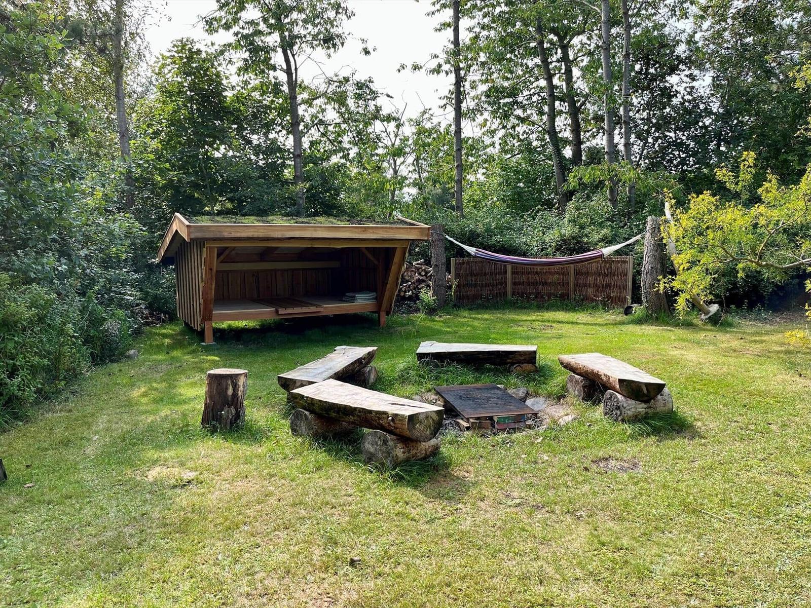 Ein Raum mit einem Holz-Kinderstockbett, zwei Stühlen und einem Spiegel an der Wand.