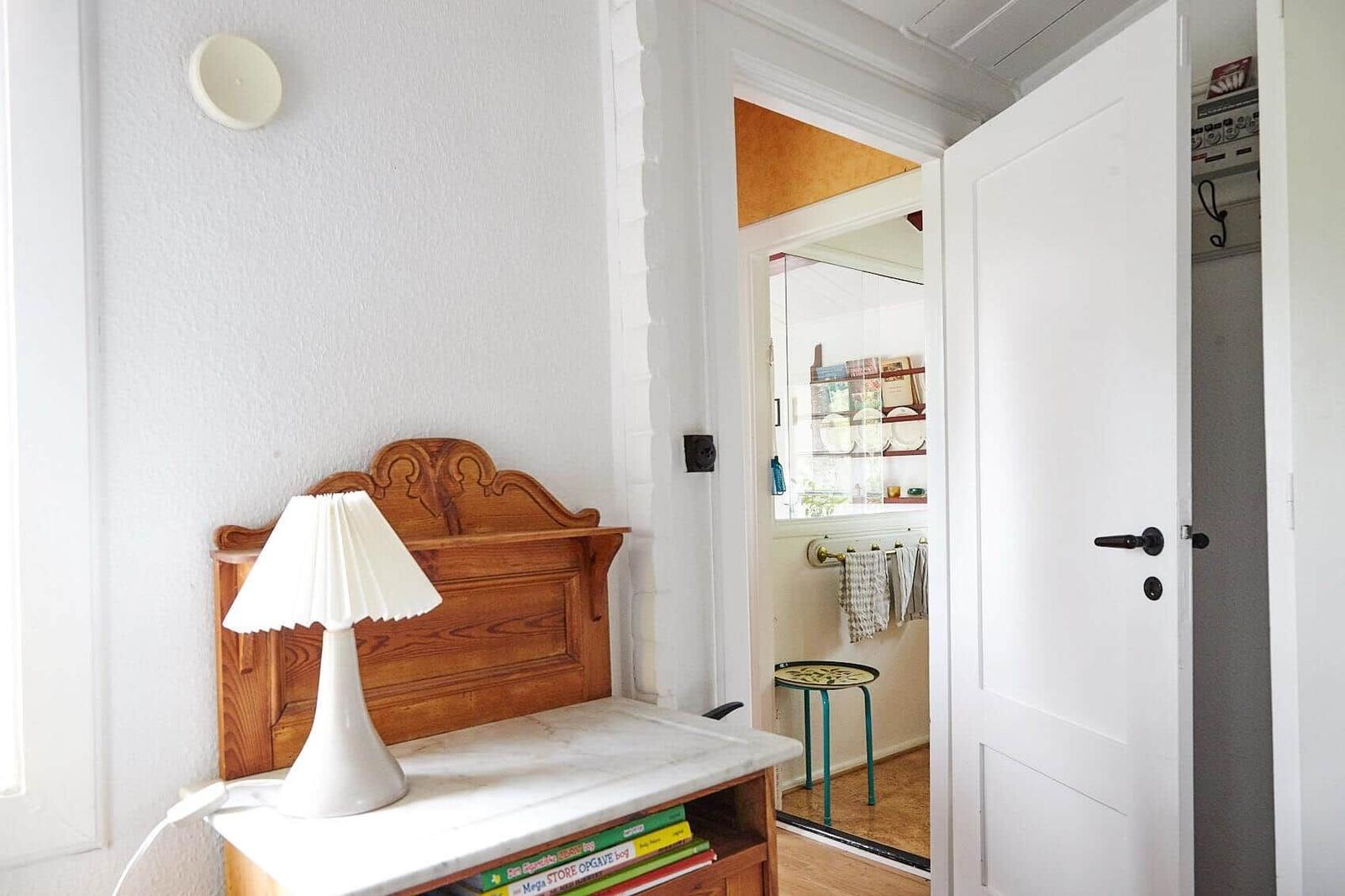 Wohnzimmer mit Sofa, Sessel, Bücherregal und Fenster.