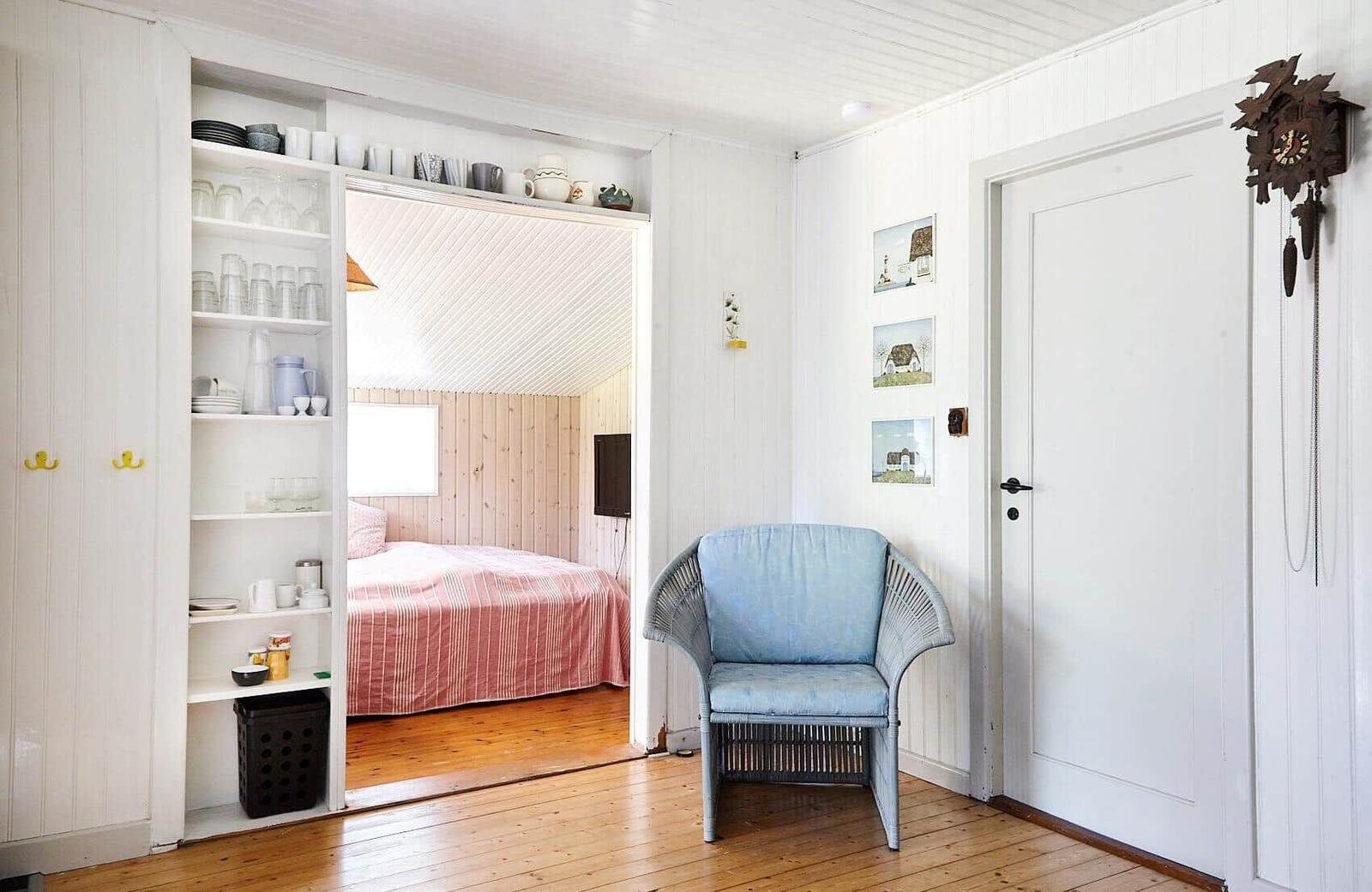 Zimmer mit Doppelbett, oberem Bett und Fenster mit Vorhang.