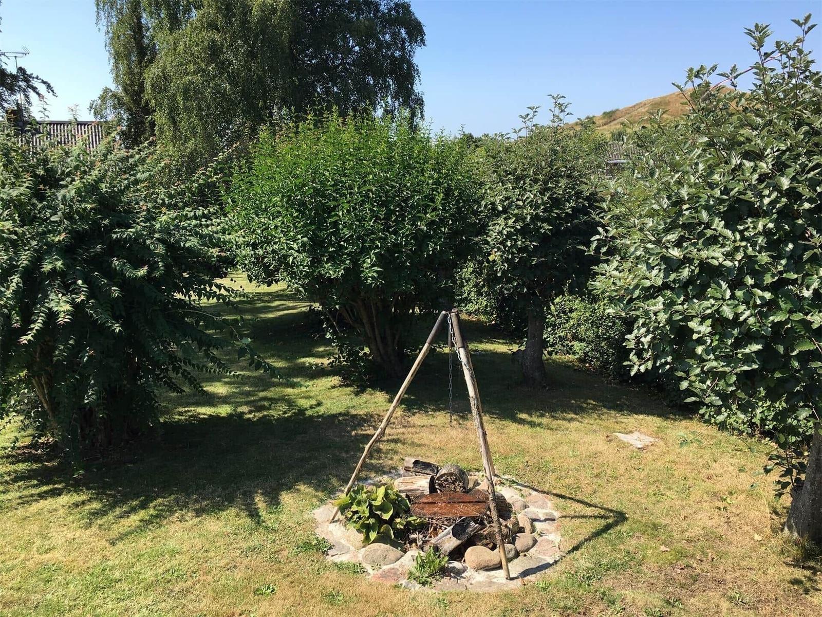 Terrasse mit Blick auf See und Grünflächen durch große Glasschiebetüren.