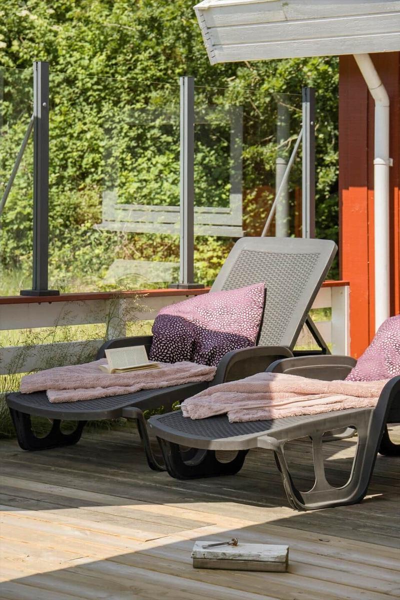 Schlafzimmer mit Bett, Kleiderschrank und Fenster mit Blick auf Bäume.