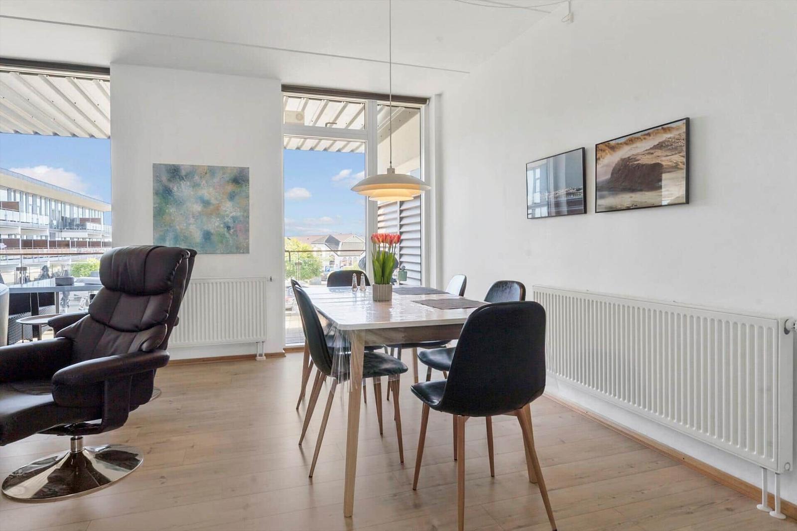 Schlafzimmer mit Doppelbett, Holzwand und Fenster zum Balkon.