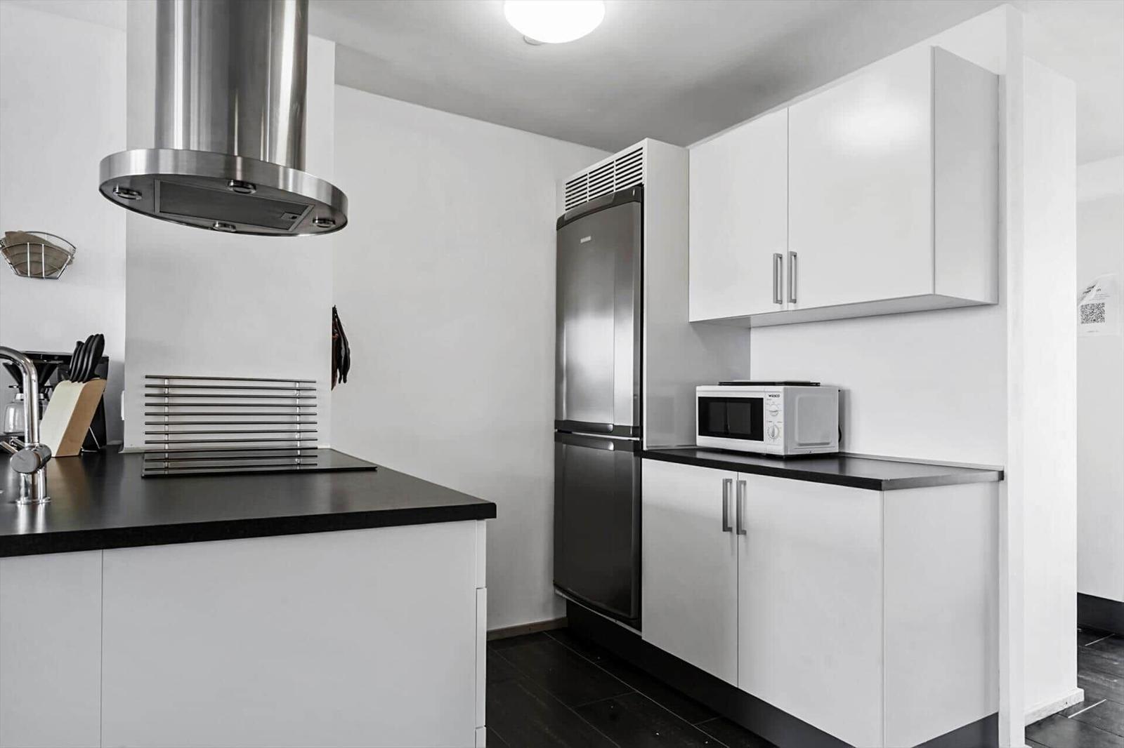 Wohnung mit Küche, Schlafzimmer und Bad. Raumübersicht mit Kompass.