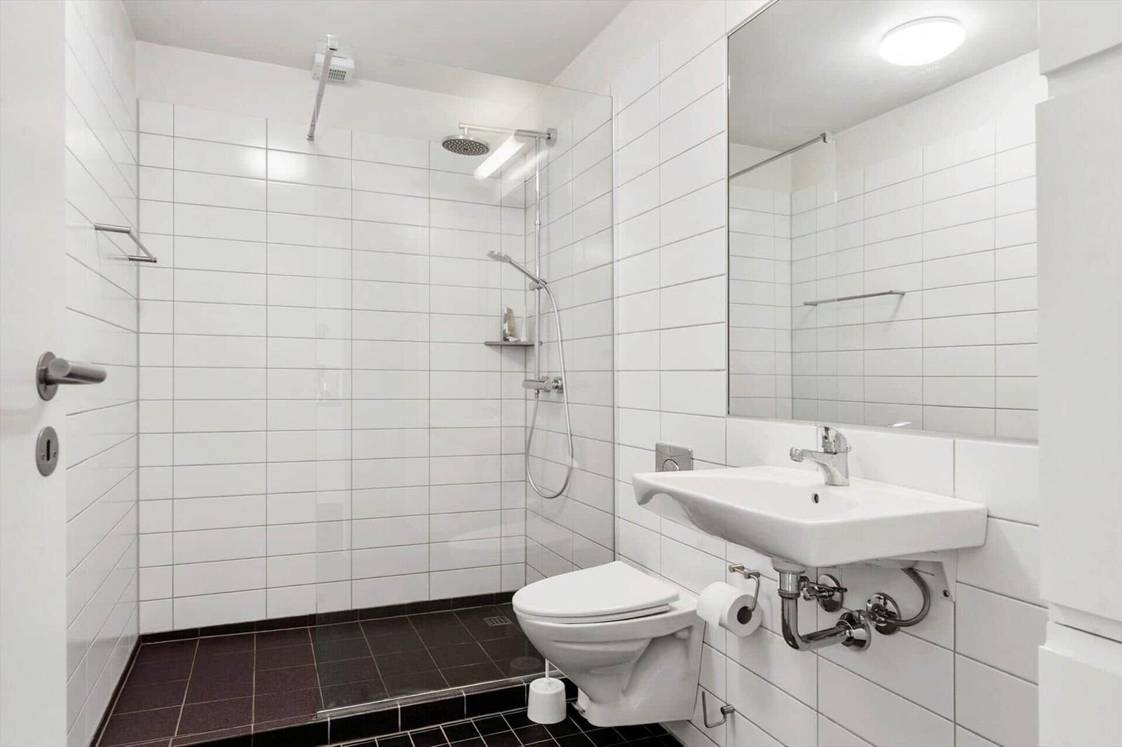 Essbereich mit Tisch und Stühlen, Küche im Hintergrund und Kamin im Wohnbereich.