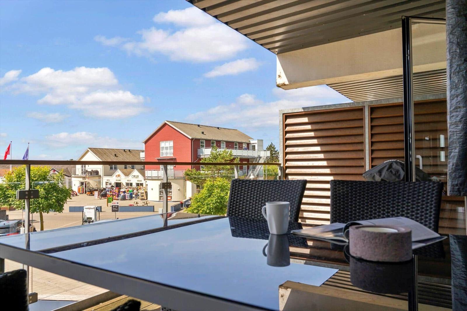 Essbereich mit Tisch, Stühlen und Blick auf Balkon. Wandbild und Heizkörper sichtbar.