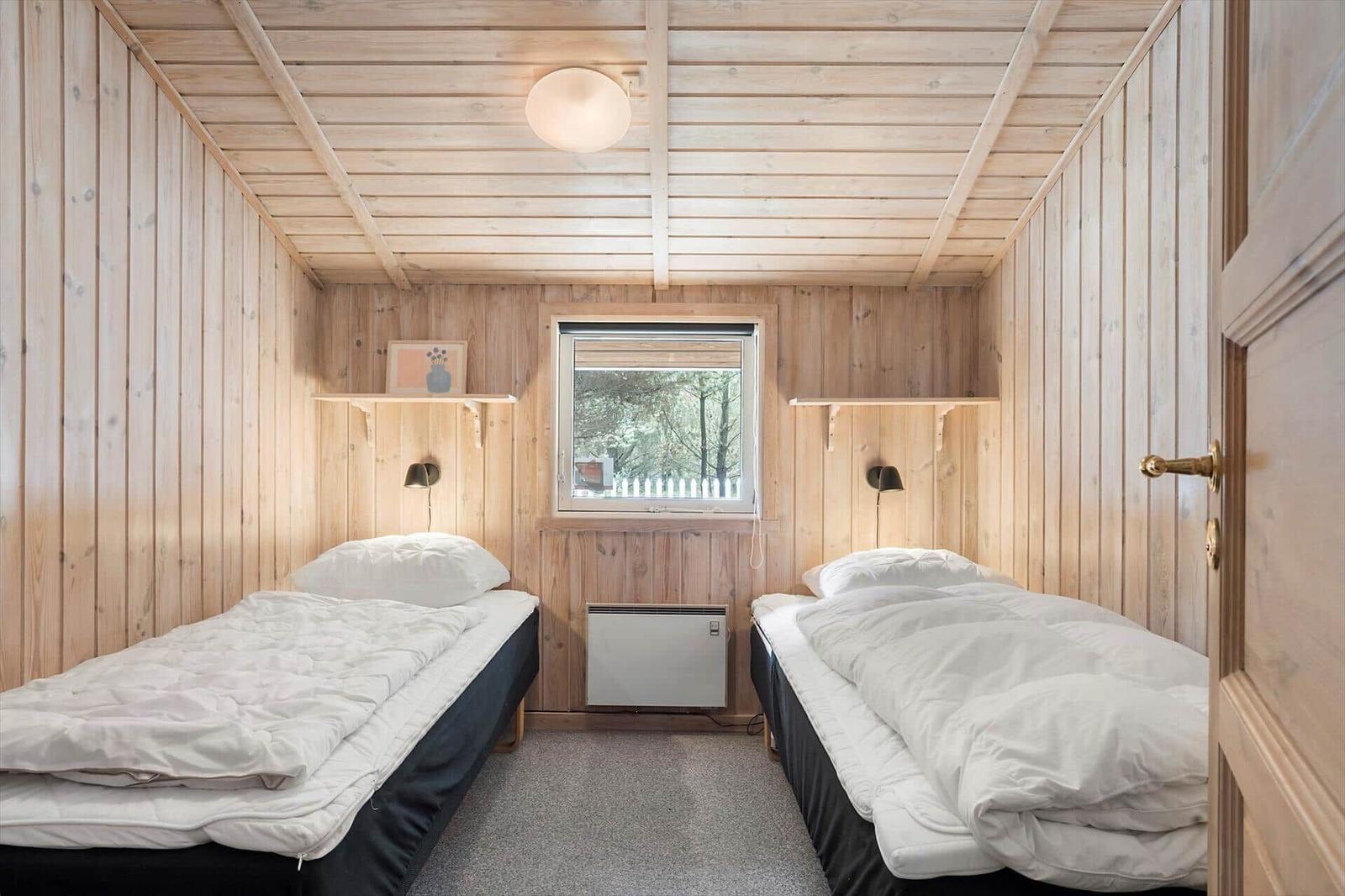 Haus mit weißem Zaun und grauem Dach zwischen Bäumen