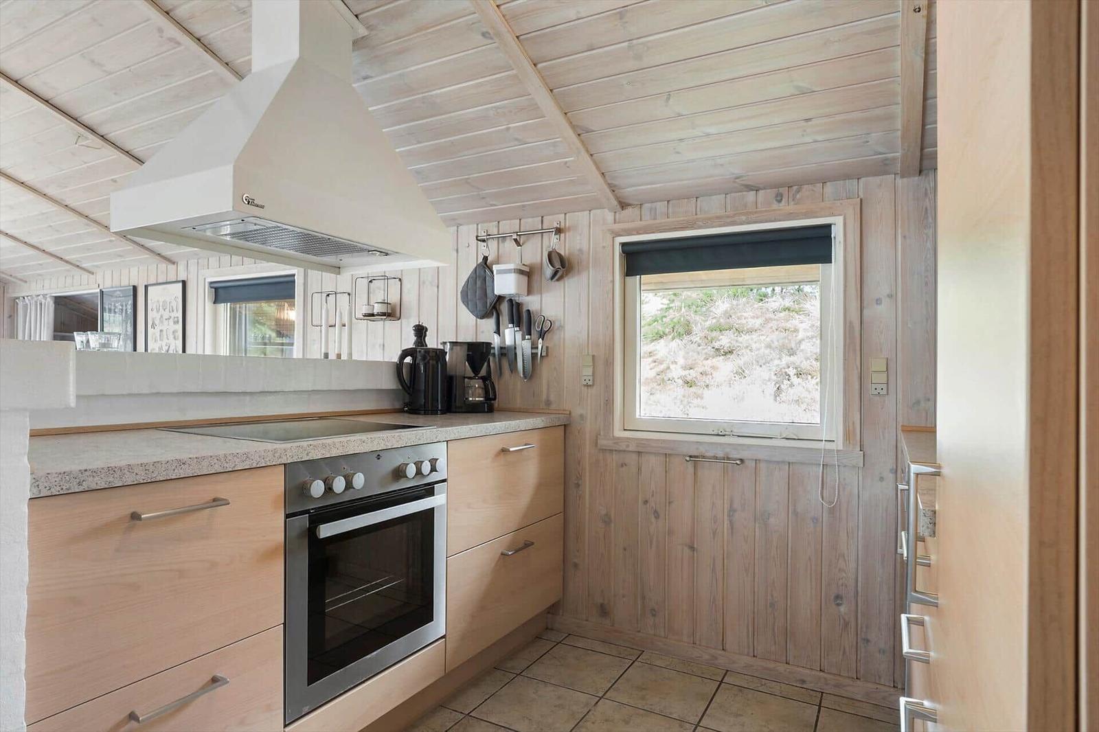 Zwei Einzelbetten in einem holzverkleideten Raum mit Fenster und Heizung.