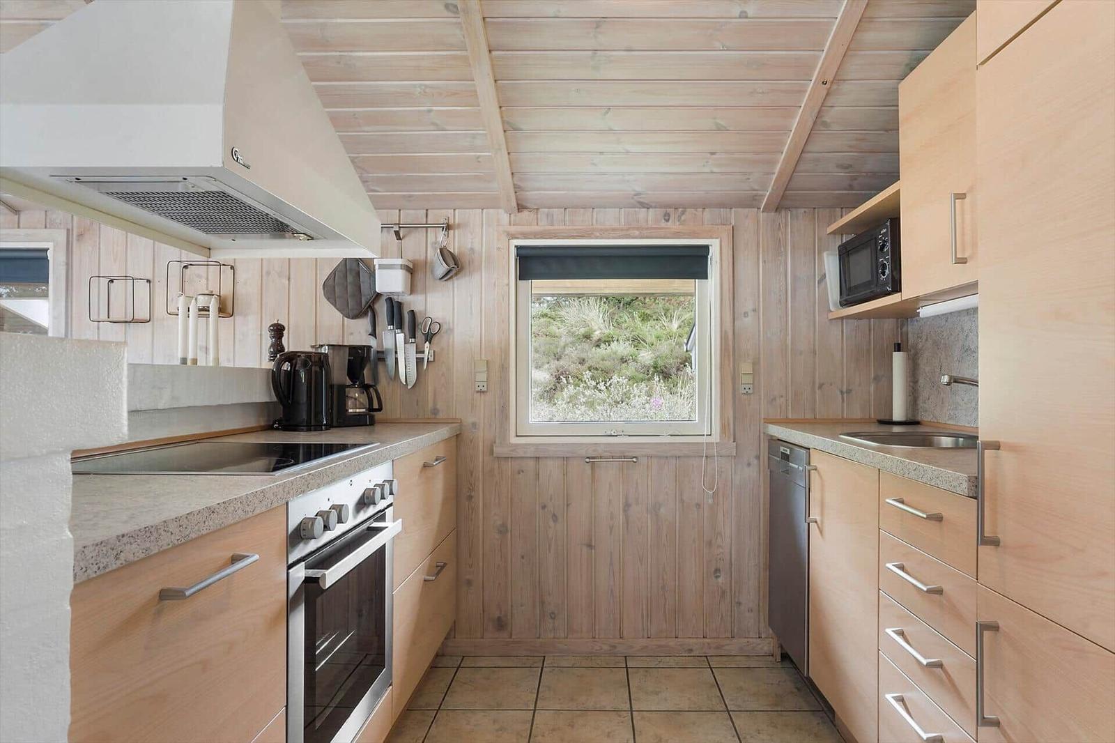 Sauna mit Holzwand, Holzbänken und einem Holzwaschbecken mit Deckel.