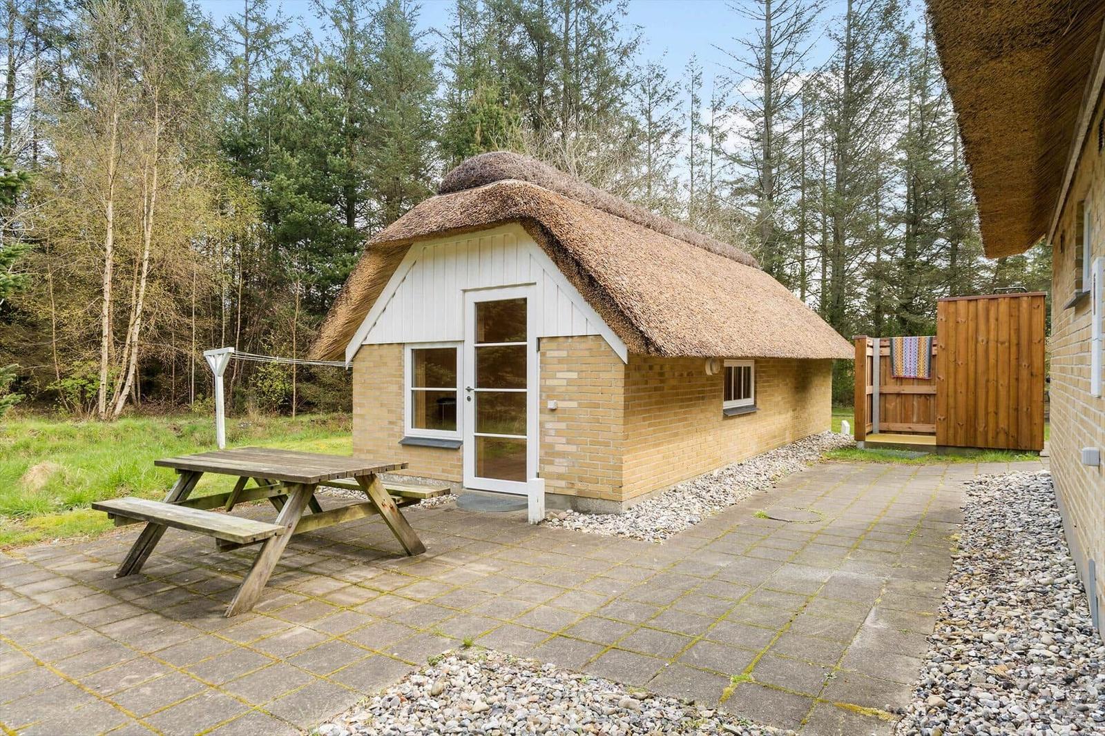 Badezimmer mit Holzdecke, Waschbecken und Toilette unter einem Dach