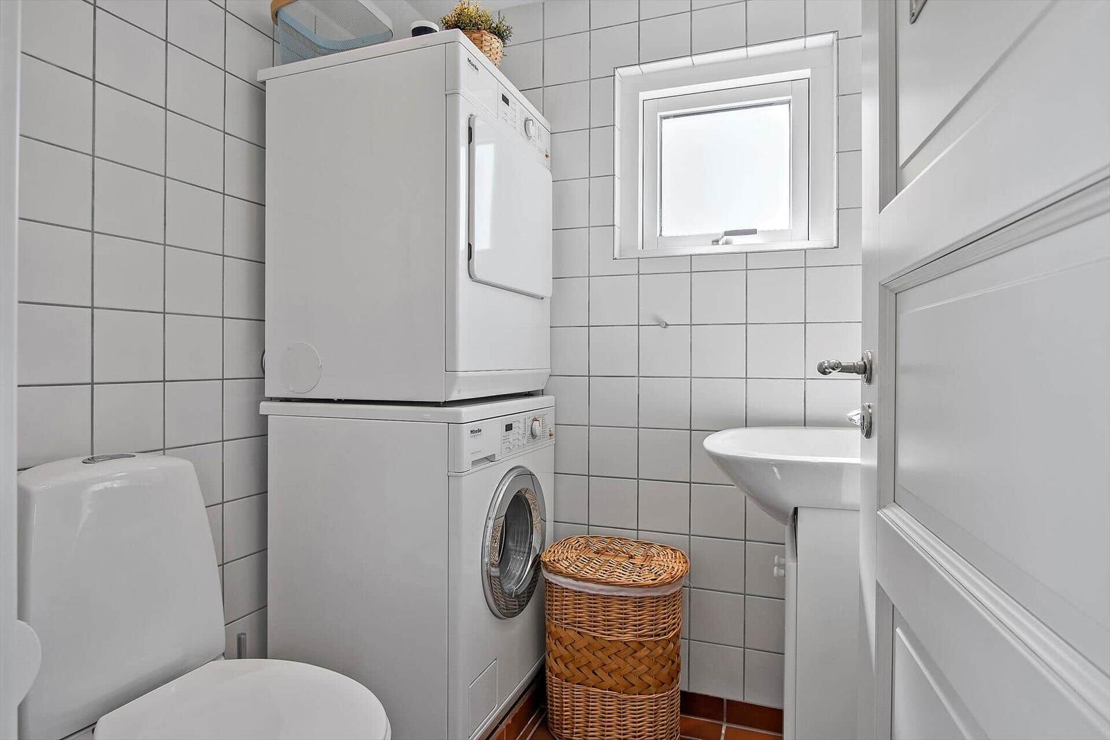 Haus mit gelbem Anstrich und rotem Dach, gepflasterter Hof mit Tisch und Stühlen.