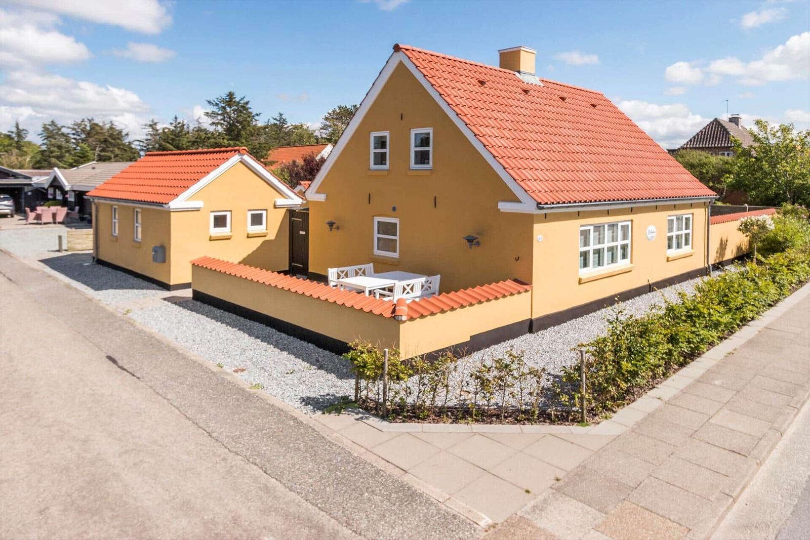 Eine Küche mit weißen Schränken, grauen Arbeitsplatten und einem Fenster mit Blick nach draußen.