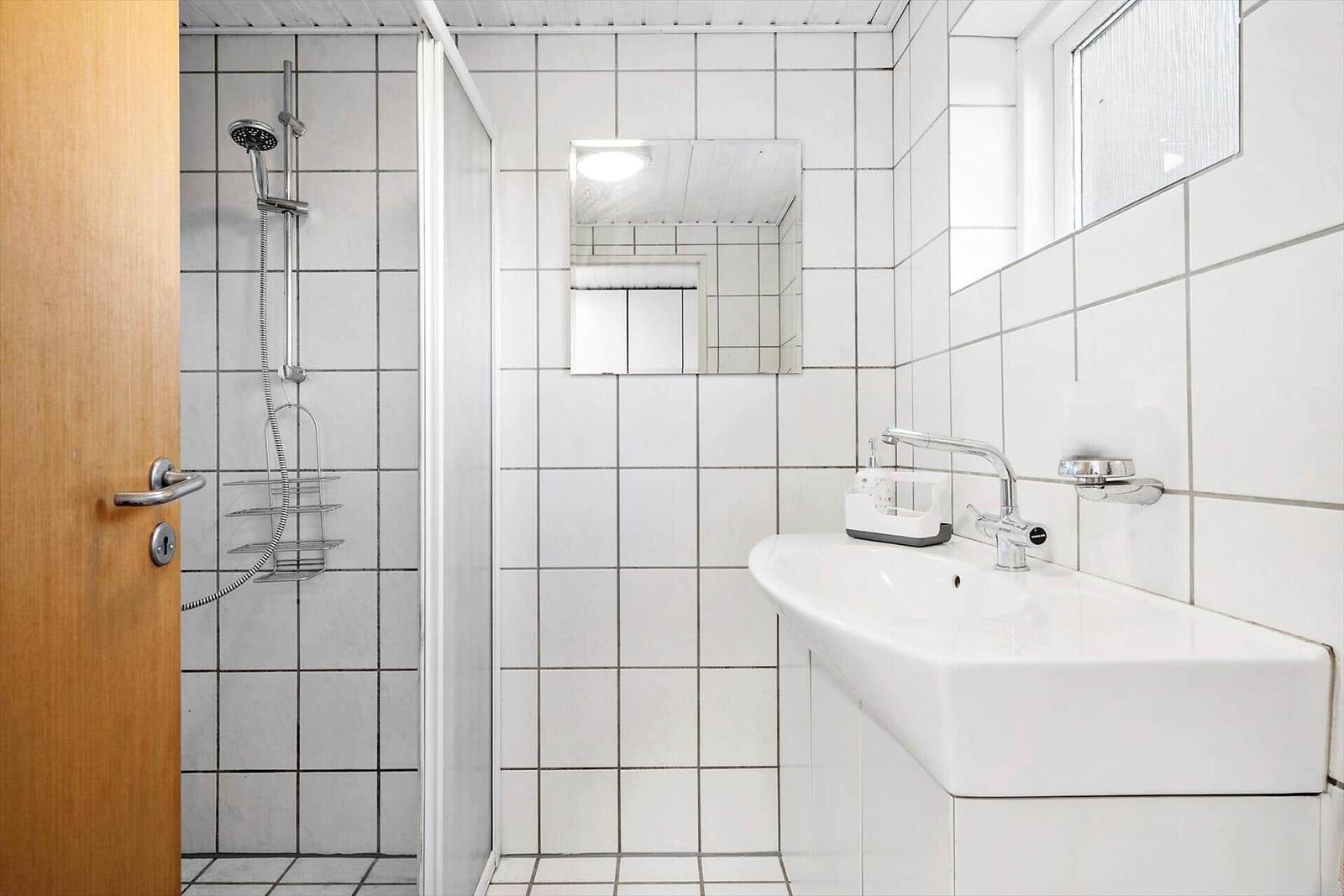 Schlafzimmer mit Dachschrägen, Bett, Stühlen und Fenstern.