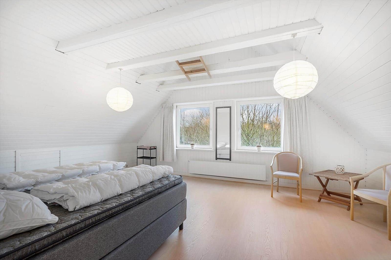 Wohnzimmer mit Sofa, Fenster und Deckenbalken
