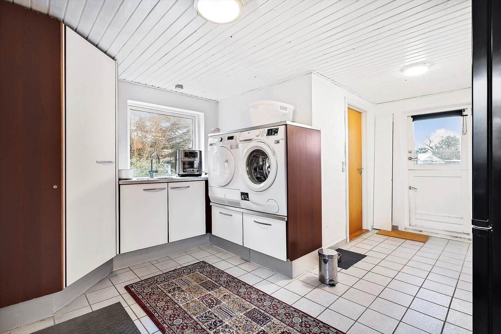 Schlafzimmer mit Dachschräge, Fenster und Bett mit gelber Decke.