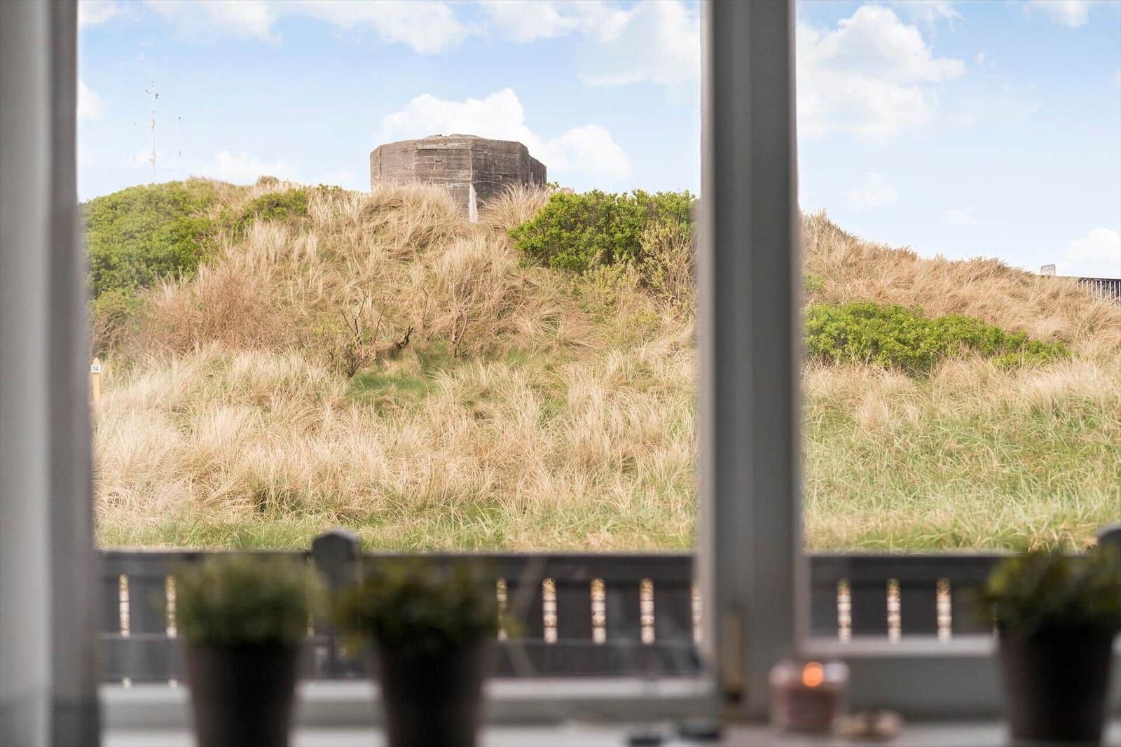 Terrasse mit Holztisch, Stühlen und Pavillon. Hintergrund: Holzwand und Fenster.