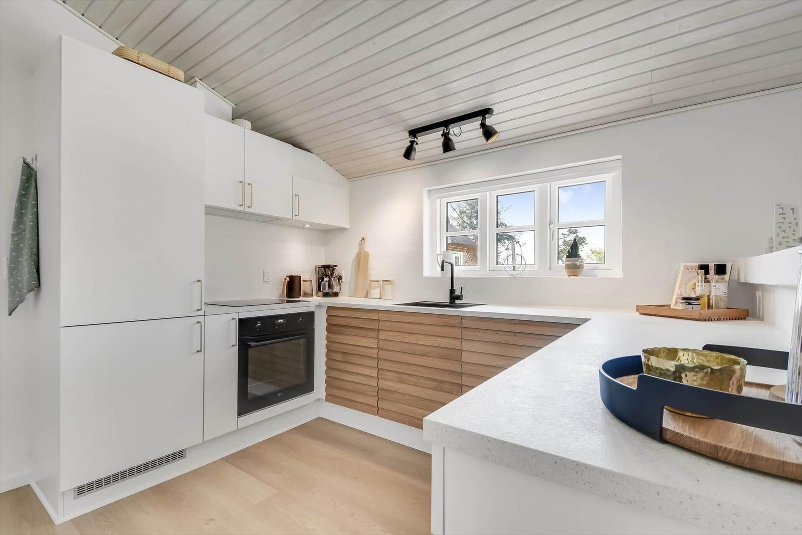 Essbereich mit Holztisch, schwarzen Stühlen und moderner Hängelampe.