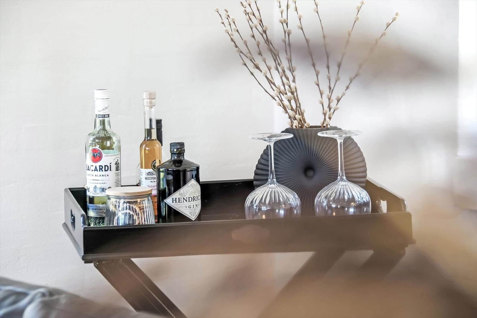 Wohnzimmer mit zwei schwarzen Ledersofas, Glas-Tisch und Kaminofen.