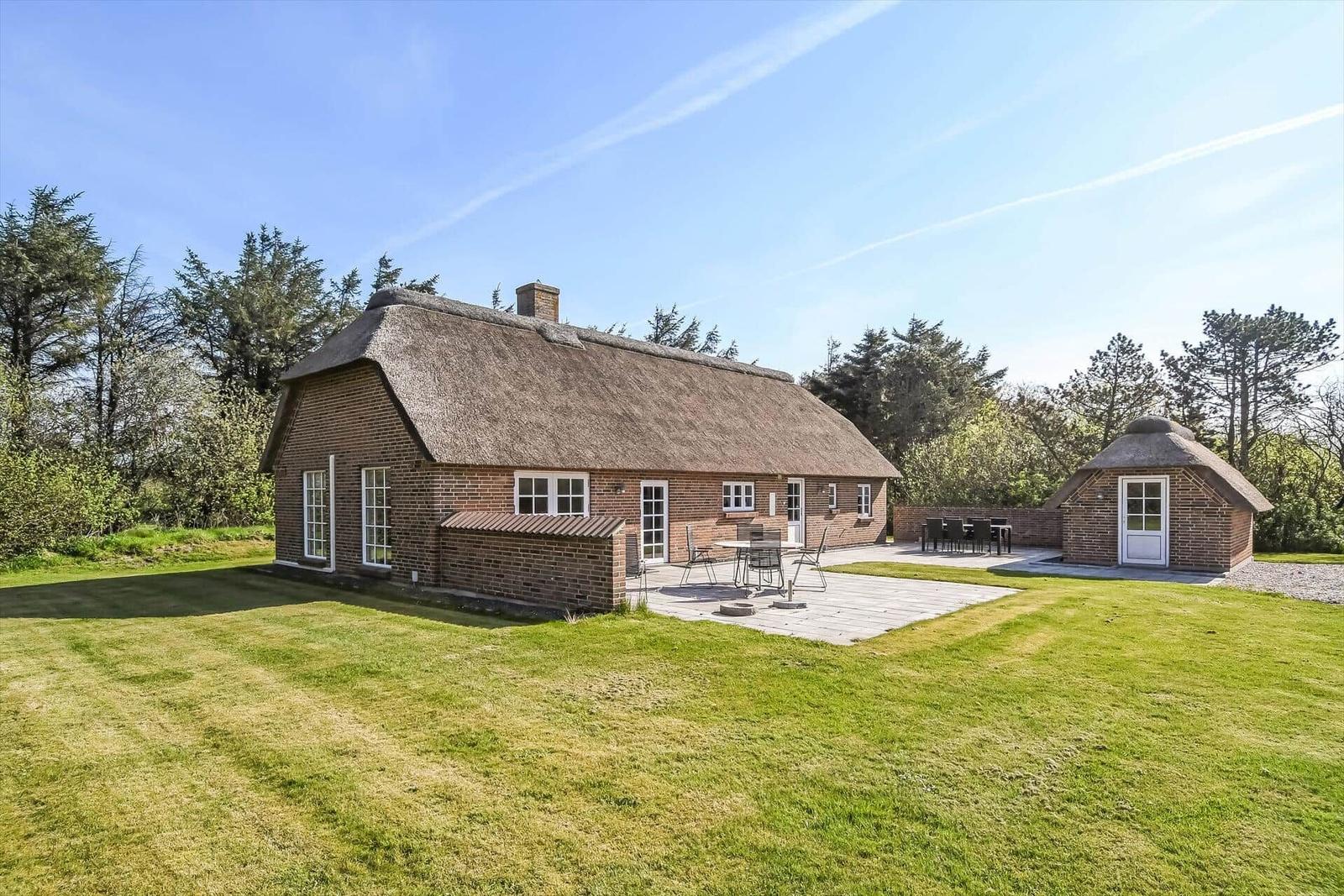 Haus mit Strohdach, Terrasse und Gartenweg