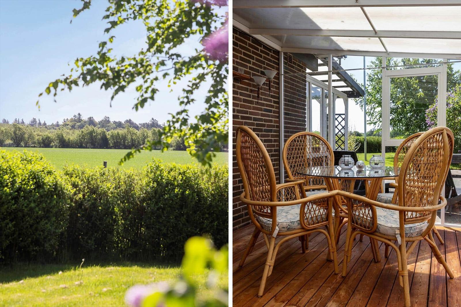 Two rattan chairs with floral cushions and a table on a wooden deck.