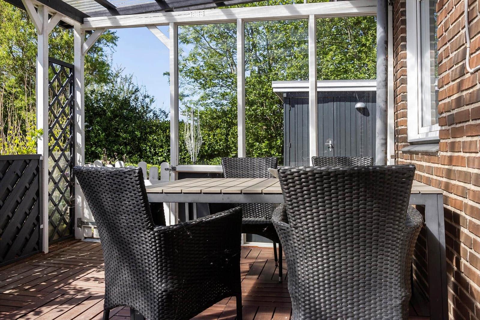 Patio with rattan furniture and view of green meadows.