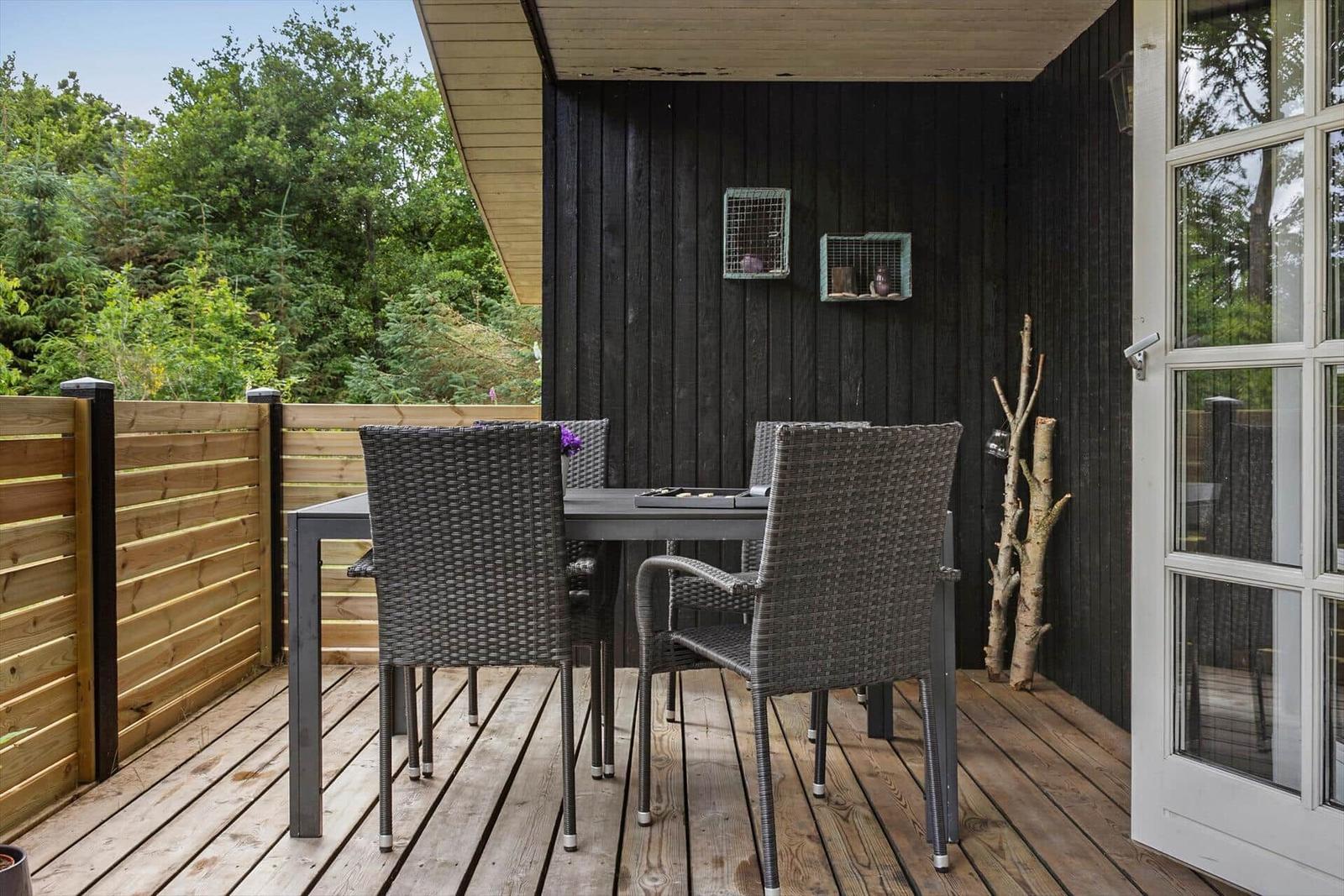 Backgammon set with dice and table in outdoor area with garden furniture and plants.