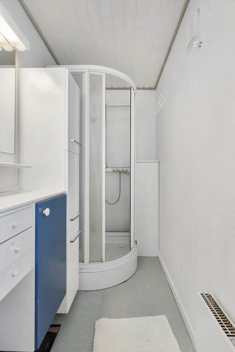 Bedroom with bed, chairs, and bookshelf against the wall.