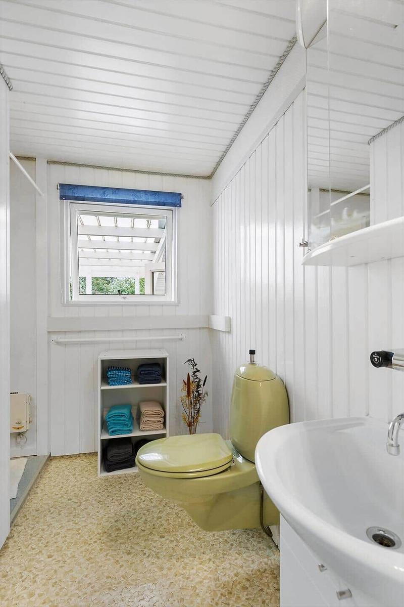 Bathroom with shower, sink, and blue cabinet door.