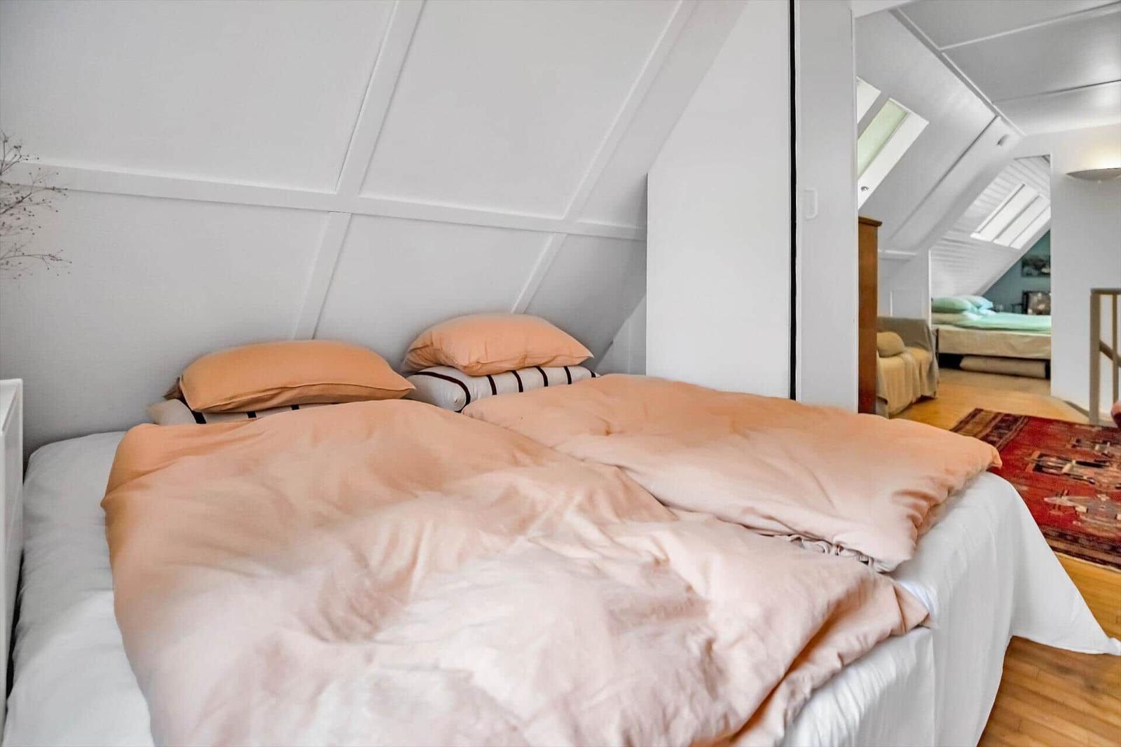 Essbereich mit weißem Tisch, grünen Stühlen und Holzboden. Fensterbank mit Kerzen und Lampe.
