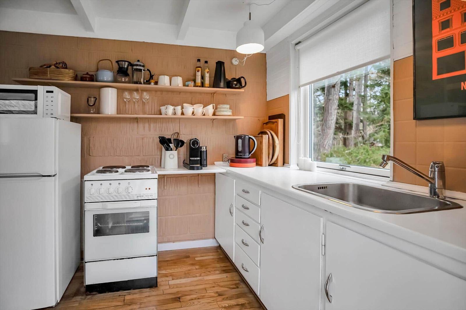 Haus mit Terrasse, Garten und Grillplatz. Holzdecke, Fenster und Türen.