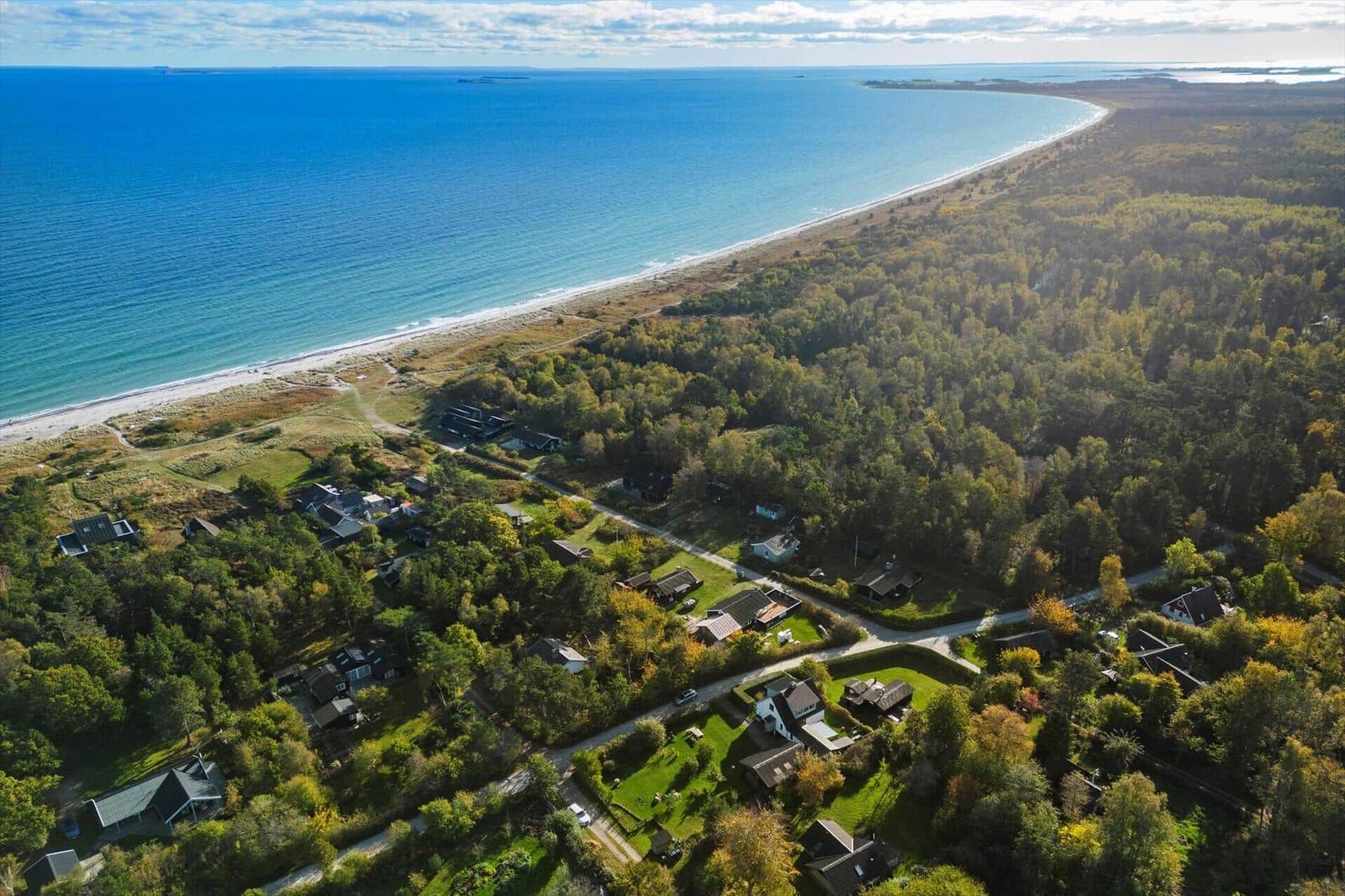 Zwei Boote mit Personen auf ruhigem Wasser vor grünen Hügeln.