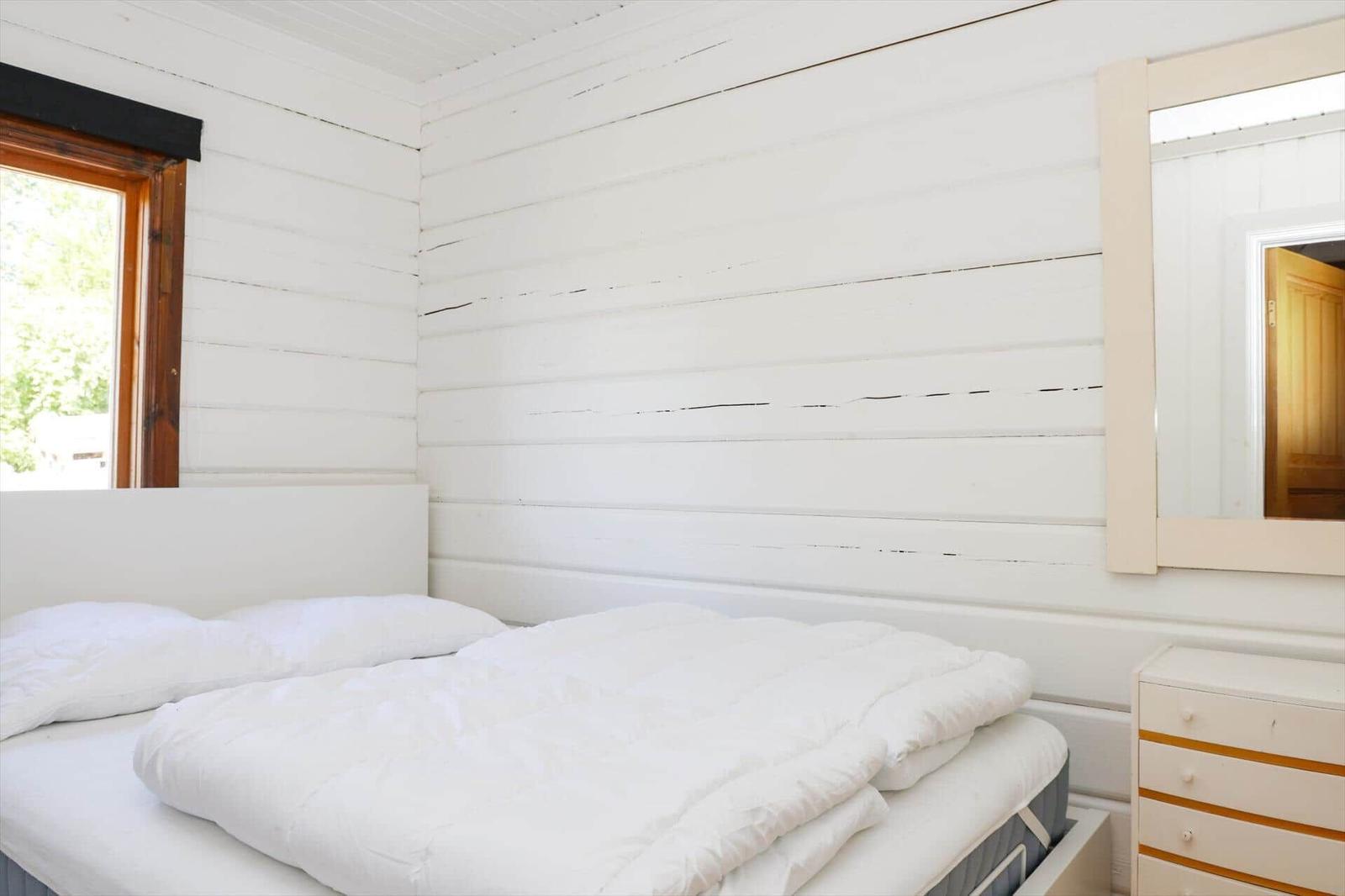 Badezimmer mit Toilette, Waschbecken und Dusche. Fenster und Spiegel sichtbar.