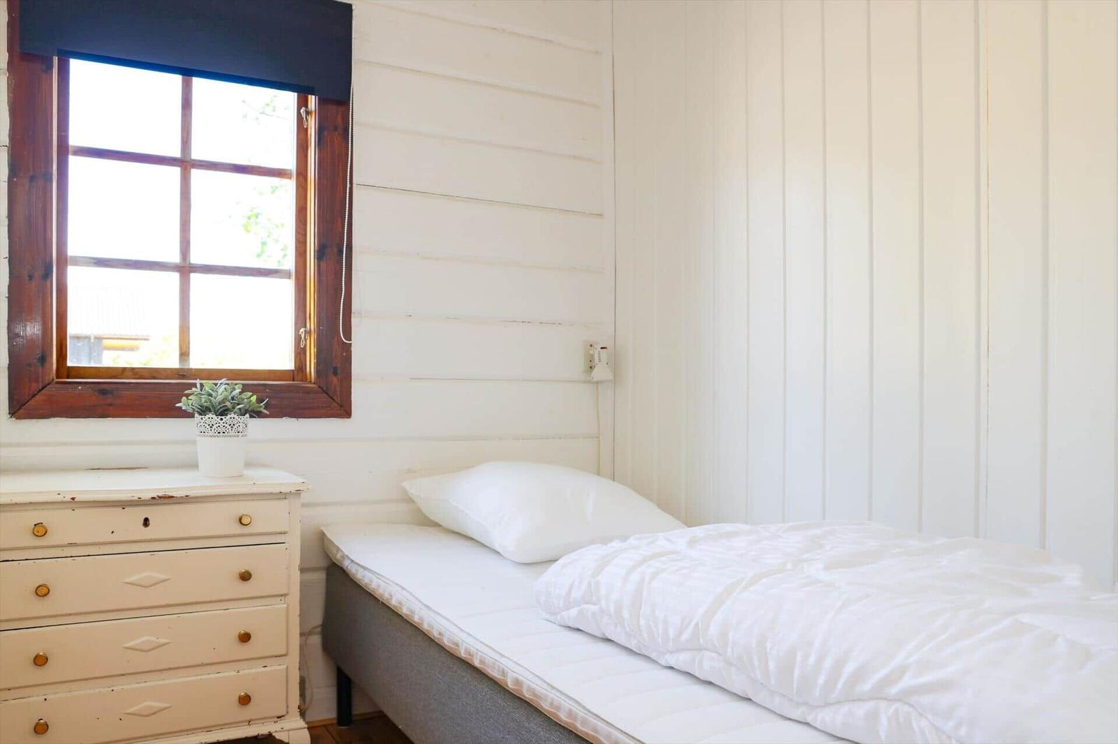Flur mit Holztüren und Schrank. Blick in Schlafzimmer mit Bett.