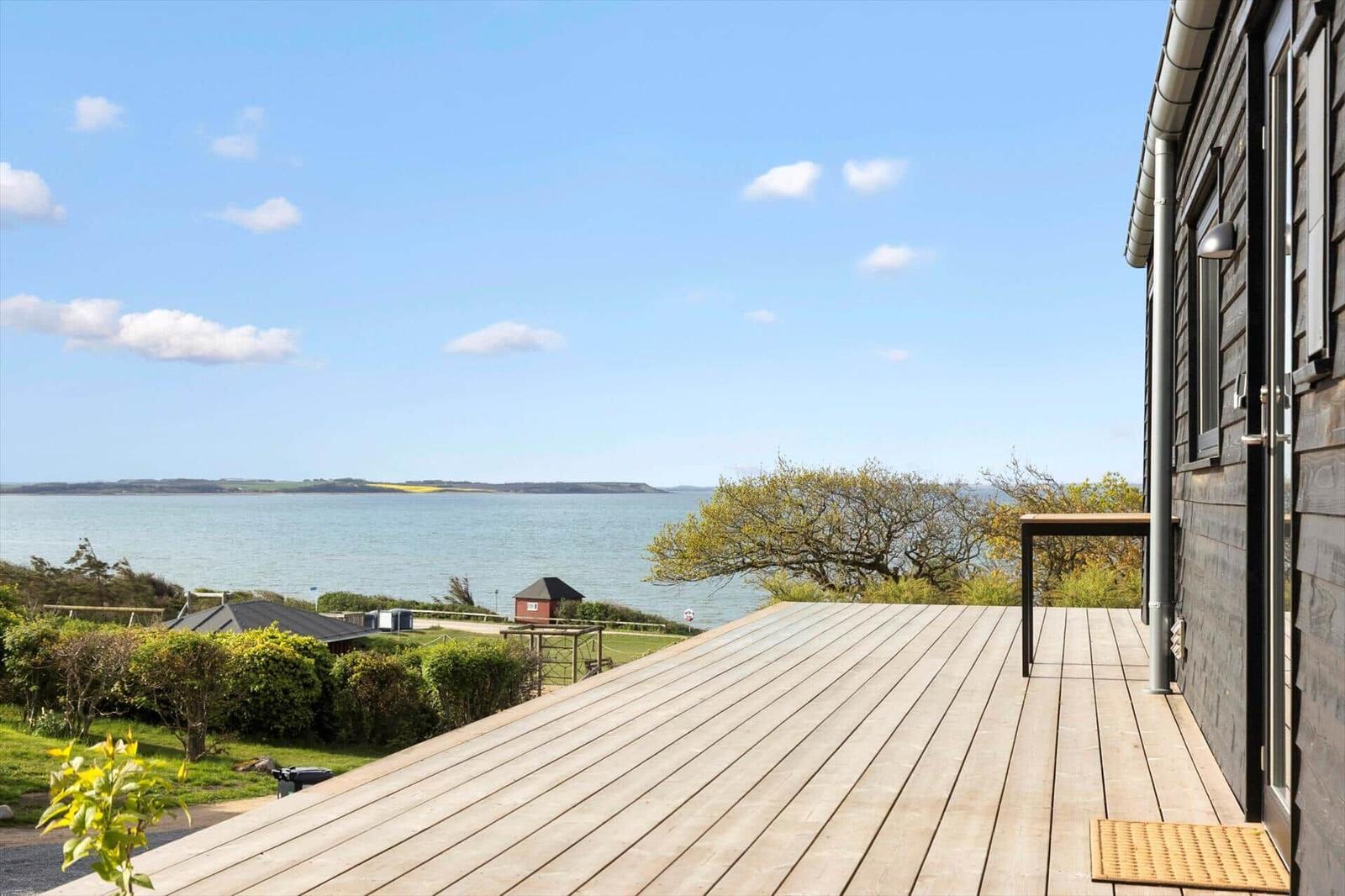 Terrasse mit Blick aufs Meer und grüne Landschaft.