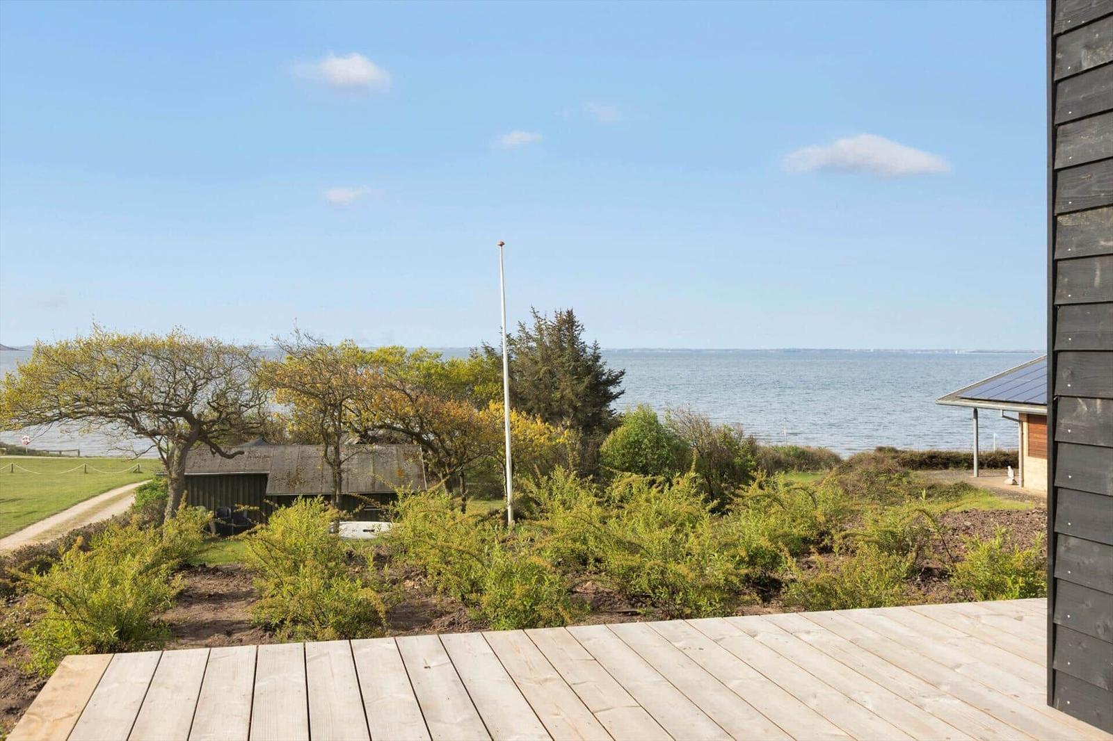 Terrasse mit Blick aufs Meer und grüne Landschaft.