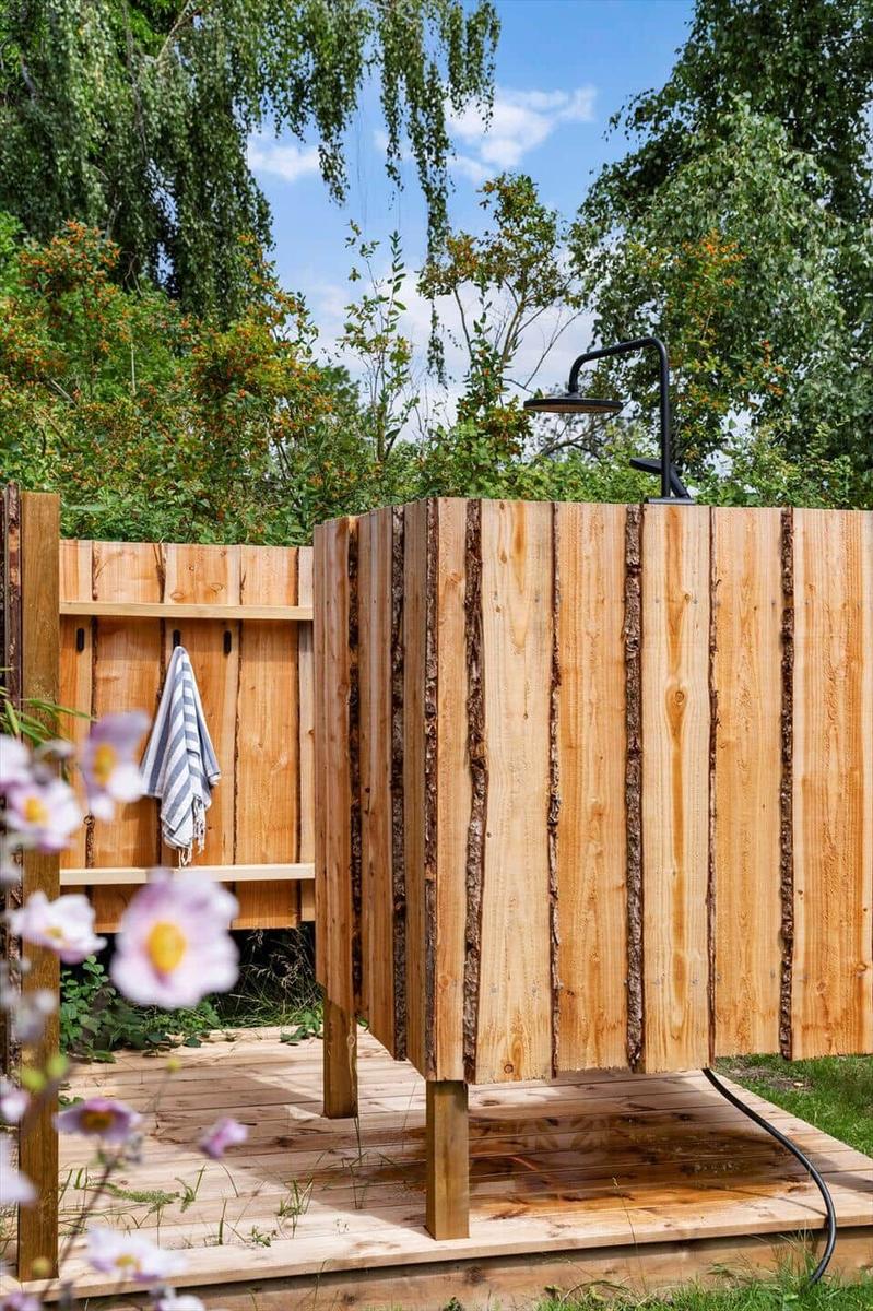 Hängem施 in Garten mit Blick auf Bäume. Holzspielgeräte auf Rasen.