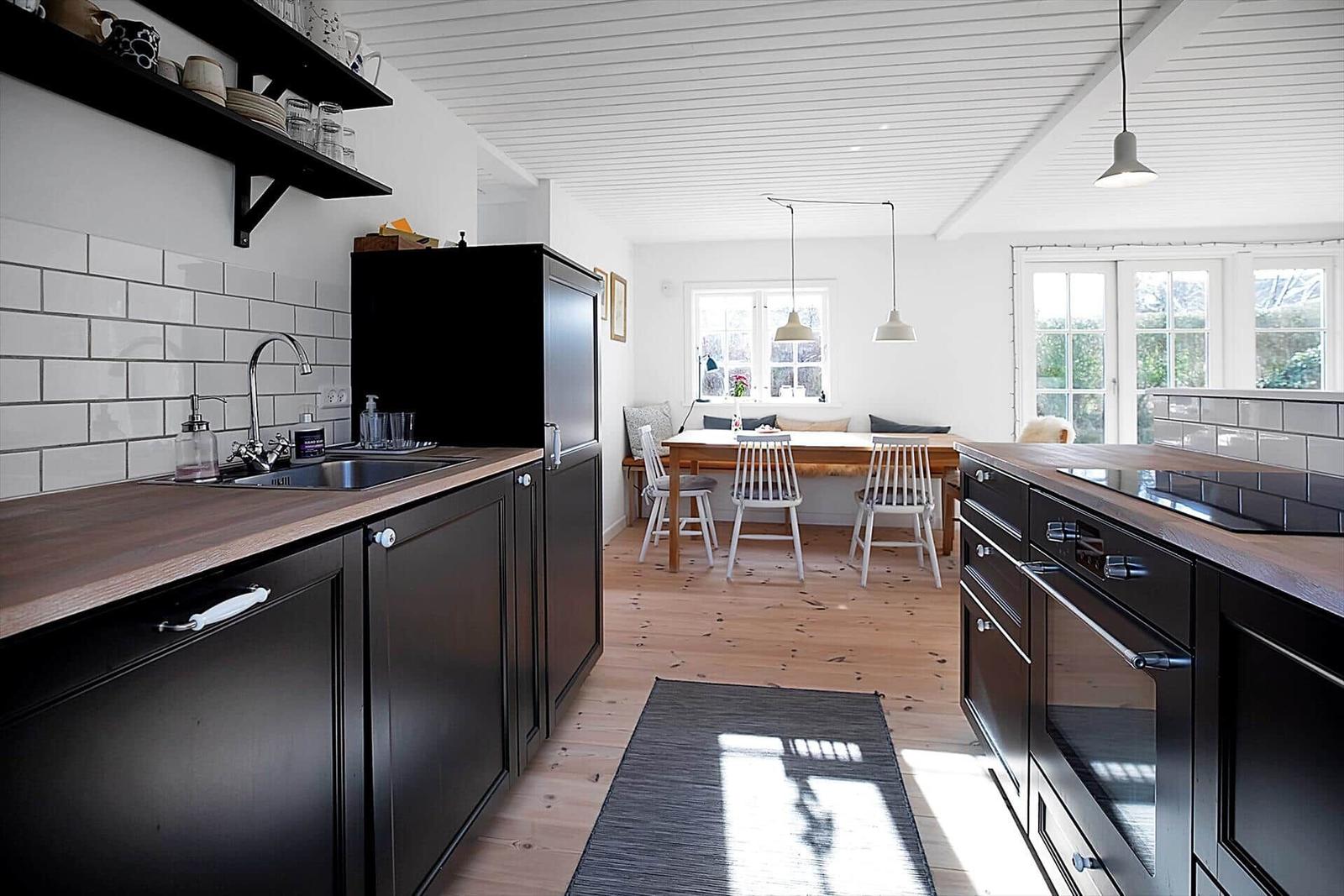 Schlafzimmer mit Bett, Nachttisch, Spiegel und Holzschrank. Fenster und Dachfenster sorgen für Licht.