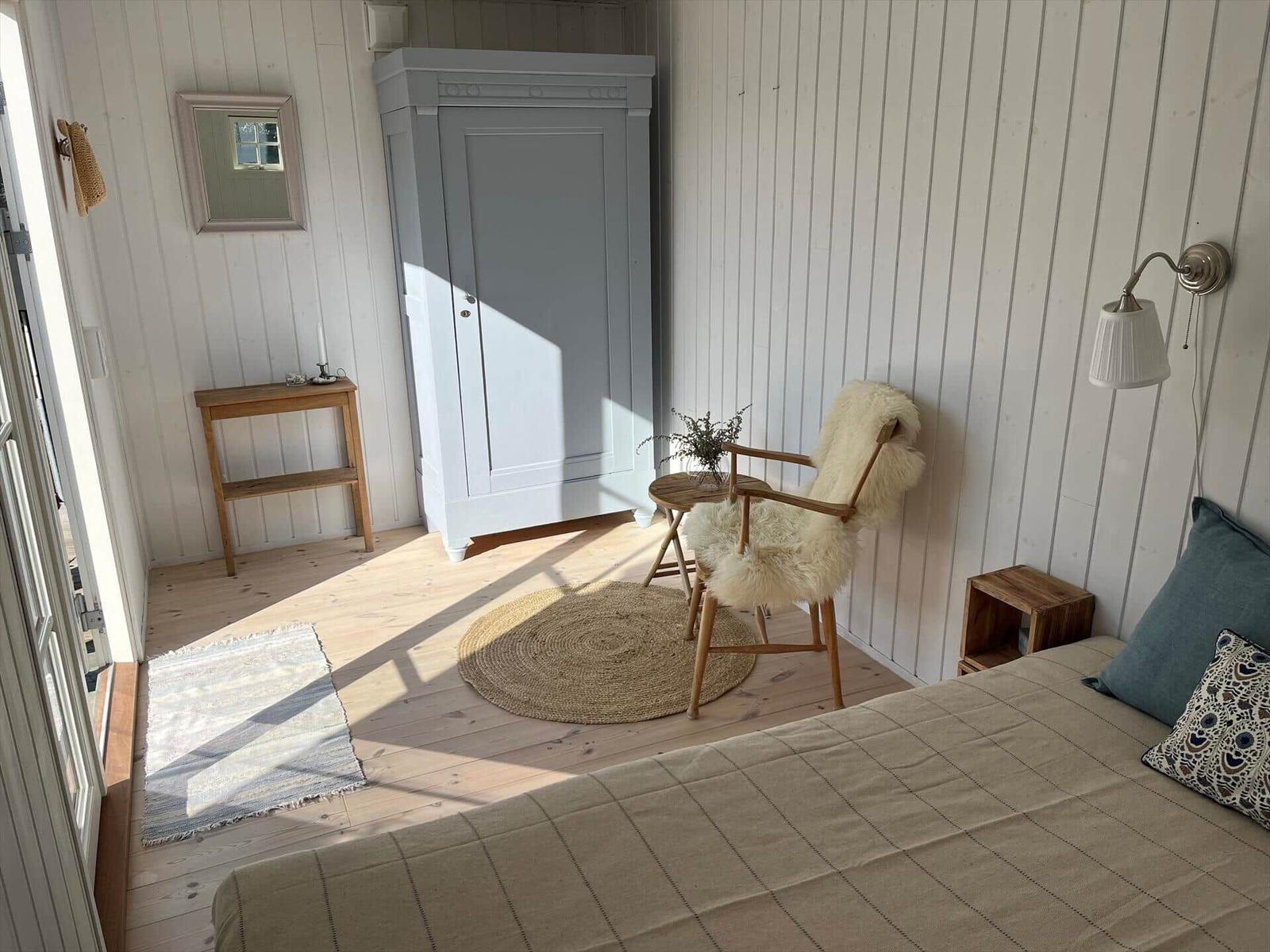 Sofa mit Kissen und Holzregal neben Wand