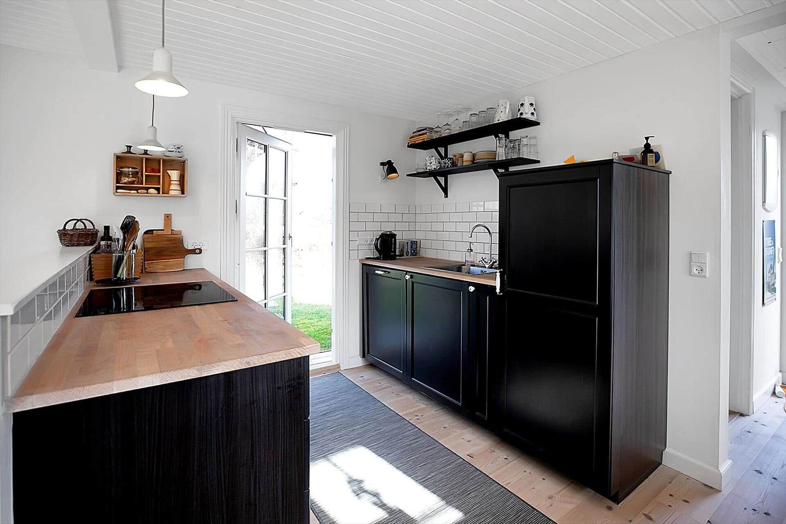 Schlafzimmer mit Bett, Stuhl und Fenster. Holzwände und -boden.
