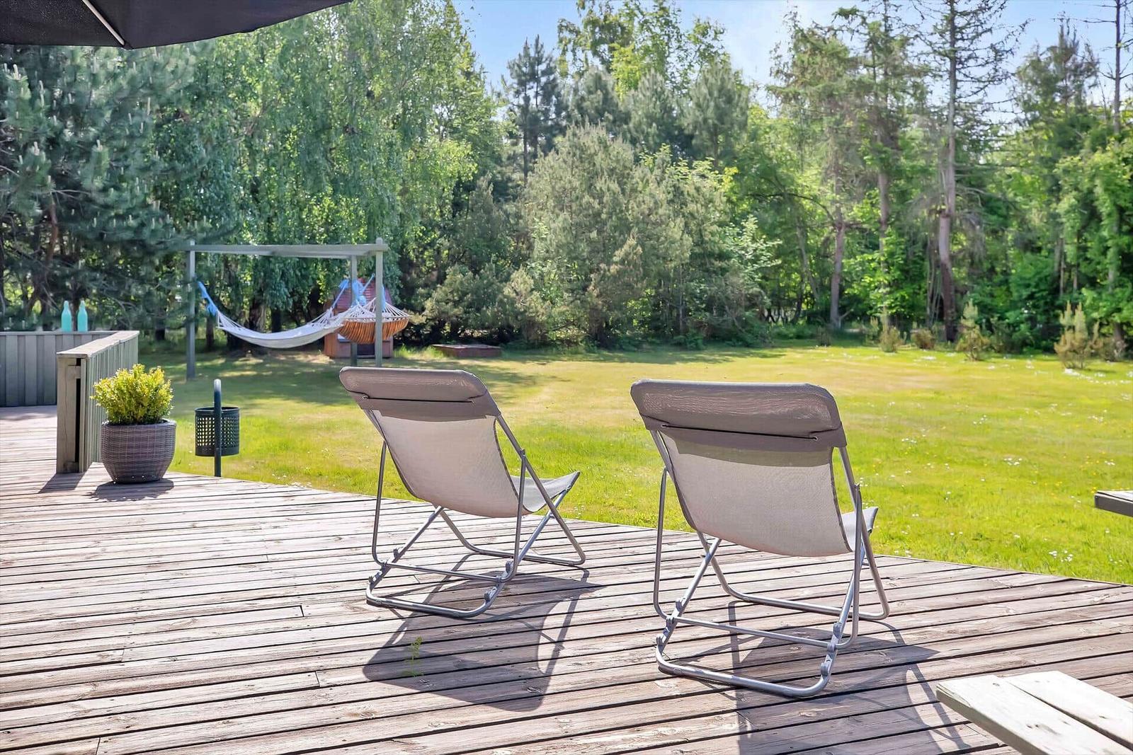 Essbereich mit Holzdecke und Küchenbereich mit grünen Deckenleuchten.