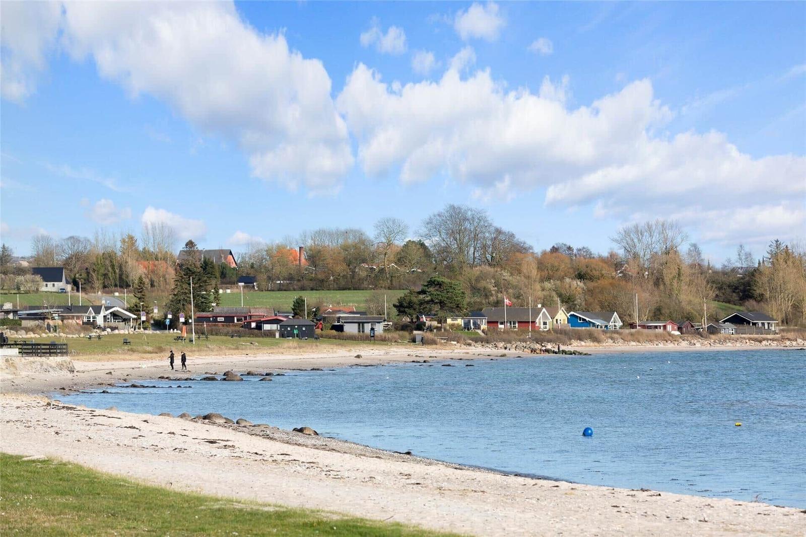 Küche mit Holzoberflächen, weißen Schränken und Blick auf die Landschaft.