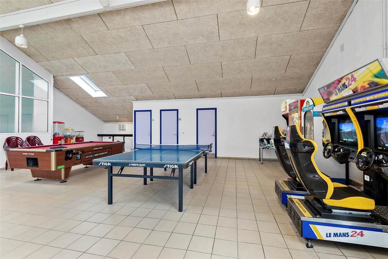 Raum mit Tischtennisplatte, Billardtisch und Rennspielsimulatoren.