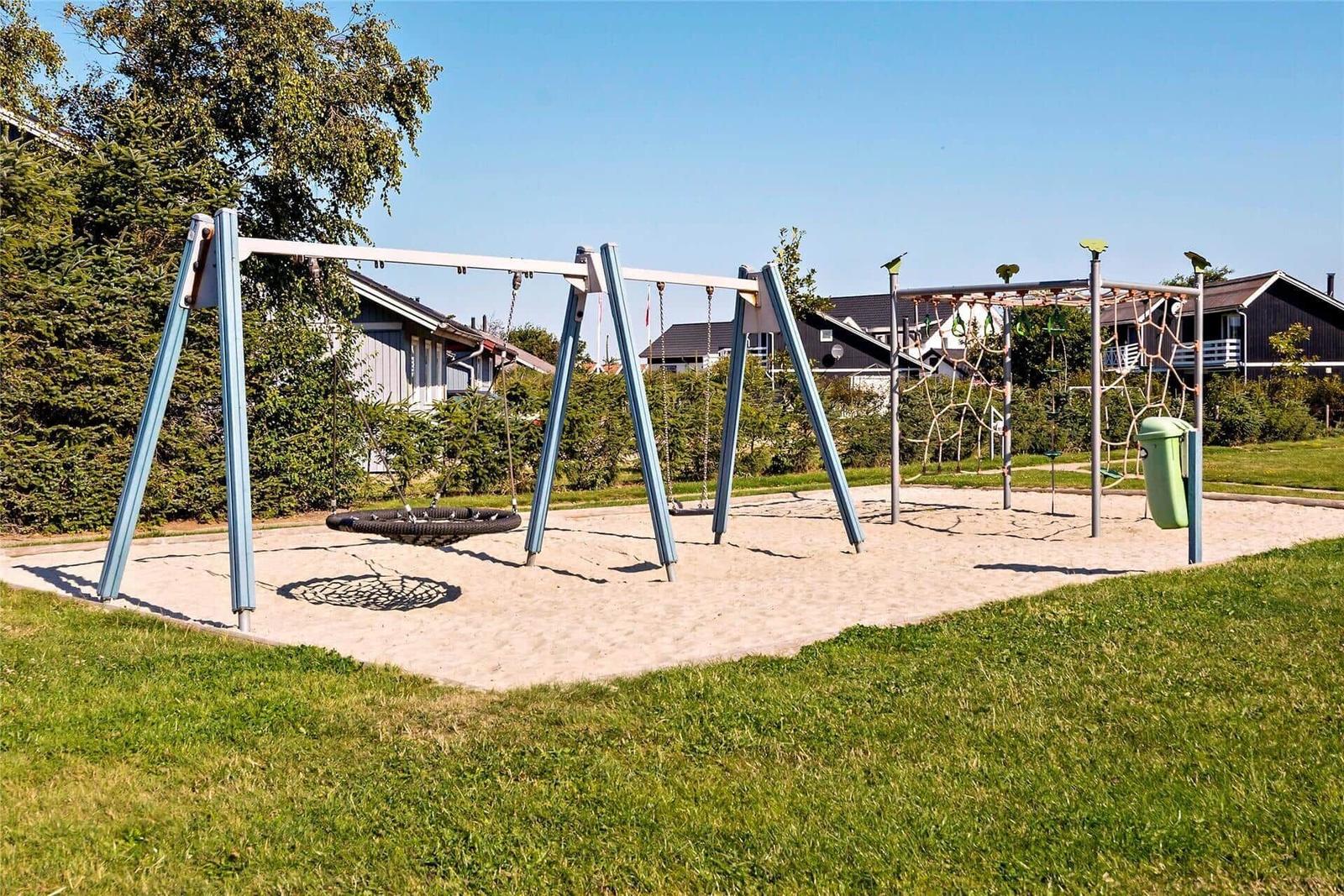 Spielplatz mit Schaukel und Klettergerüst auf Sandfläche