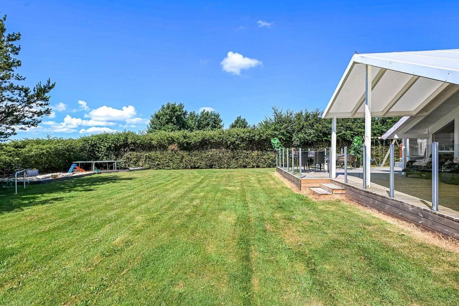 Hinterhof mit Sandkasten, Picknicktisch und Fußballtor auf grünem Rasen.