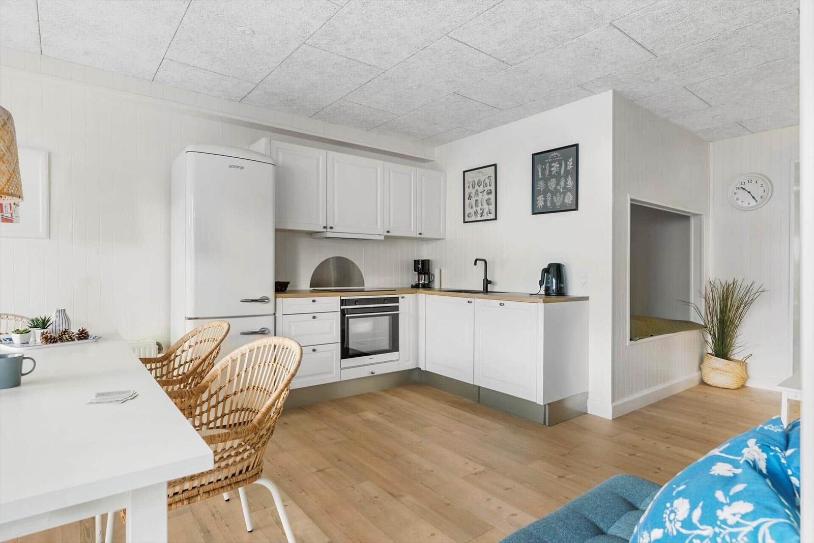 Dining area with table and chairs. Living room with sofa, coffee table, and wall art.