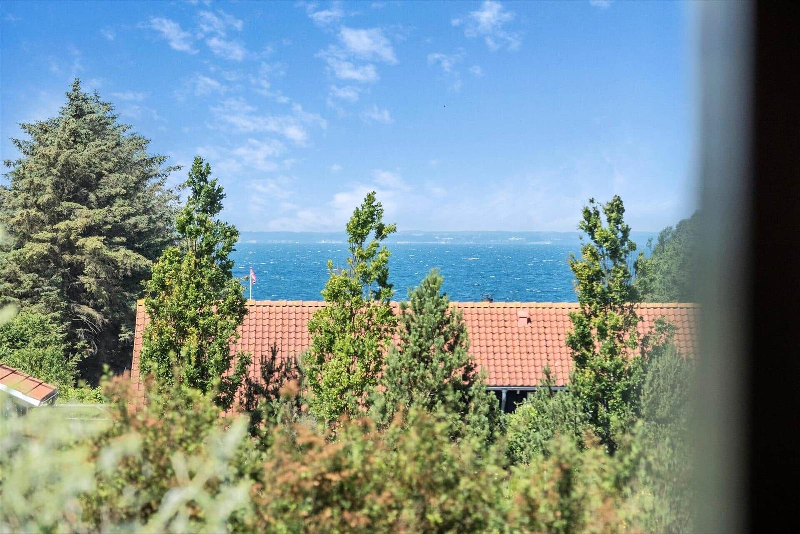 Ein Haus mit Terrasse, Grillplatz und Blick aufs Meer.